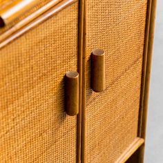 a close up view of the handles on a wooden cabinet with wicker patterning