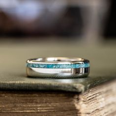 a close up of a wedding ring on top of an open book with a blurry background