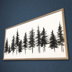 a painting hanging on the wall next to a blue wall with trees painted on it