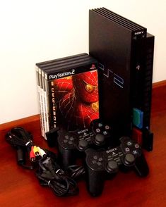 several video game controllers sitting on top of a wooden table next to a sony playstation