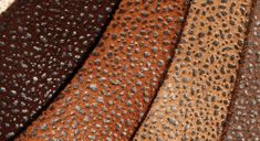 several different colors of leather with small holes in the middle one is brown, black, and tan