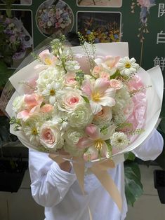 a woman holding a bouquet of white and pink flowers