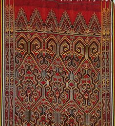 an old red rug with intricate designs on it