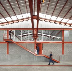 people are walking up and down the stairs in an open area with red railings