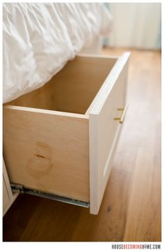 an open drawer on the side of a bed