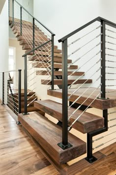 a wooden stair case with metal handrails in a home's entryway