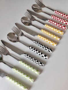 the forks and spoons are lined up in a row with different designs on them