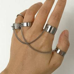 Discover the perfect fusion of goth elegance and punk rebellion with our unique Ring with Chain. This meticulously crafted piece features a robust and edgy stainless steel chain linked elegantly with a sleek ring. The adjustable band ensures a comfortable fit, making it a versatile accessory suitable for any finger. Its unisex design caters to all, embodying the true spirit of grunge and goth fashion, ideal for both everyday wear and special occasions like Halloween or themed parties. Our Finger Vampire Style, Ring With Chain, Gothic Mode, Punk Rock Jewelry, Grunge Accessories, Double Band Rings, Punk Inspiration, Titanium Jewelry, Ring Chain