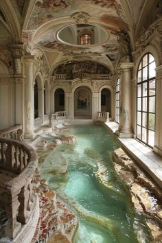 an indoor swimming pool in the middle of a large room with stone steps leading up to it