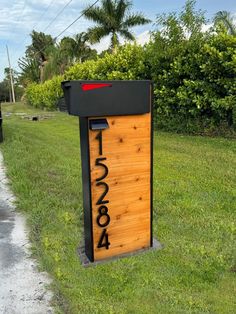 a mailbox sitting on the side of a road next to a lush green field