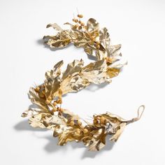 a gold leafy garland on a white background with the letter e in the middle