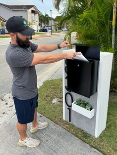 Add a modern touch to your curb appeal with the Slate Serenity Mailbox. Its sleek base and "concrete" look front panel with white wood border give a stylish look to your home. The metal locking box and solar spotlights provide security and convenience. Plus, customize it with large floating numbers and a front side planter. Base - 50"H x 25"W x10"D Front Panel "Concrete" look Tile w/ Wood White Miter Border Metal Locking Box - Top Open Box (14"W x 17"H x 7"D) 2 Retractable Ground Posts Custom La Black Mailbox, Large Mailbox, Metal Mailbox, Concrete Look Tile, Box Tops, Golden Oak, Corporate Office, House Numbers, Mailbox