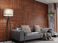 a living room with wood paneling and a gray couch in front of a lamp