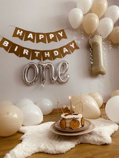 a birthday cake on a plate in front of balloons