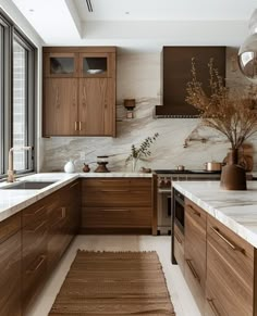 a kitchen with marble counter tops and wooden cabinets, along with a rug on the floor