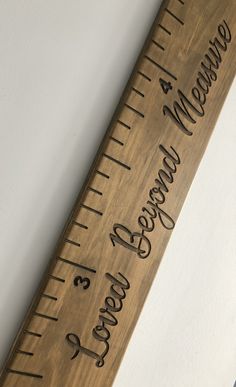 a wooden ruler with writing on it and the word measure is engraved in black ink