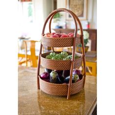 a three tiered basket filled with vegetables on top of a counter