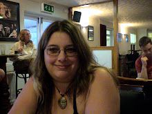 a woman wearing glasses sitting at a table