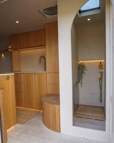 the inside of a modern home with wood and white walls, an outdoor shower area and skylight