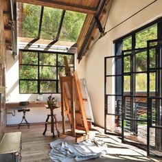 an artist's easel sits in the middle of a room with large windows