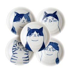 four blue and white plates with cats painted on them