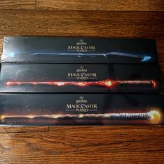 two harry potter wands sitting on top of a wooden table next to each other