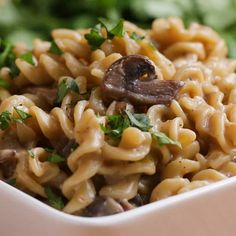 pasta with mushrooms and parsley in a white bowl