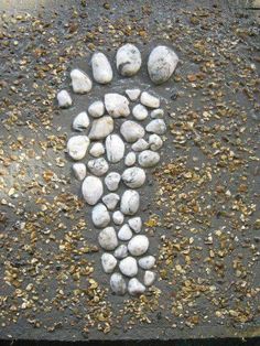 there is a foot print made out of rocks on the ground with gravel in it