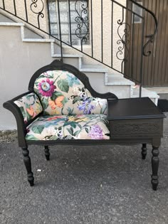 an old chair sitting on the ground next to a stair case in front of a building