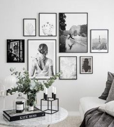 a living room with pictures on the wall and coffee table in front of couches