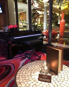 a table with a book, piano and vase on it