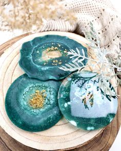 three green plates sitting on top of a wooden table next to a white and gold decoration