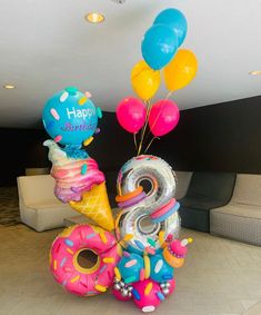 an ice cream cone, donut, and balloon birthday decoration in the shape of numbers