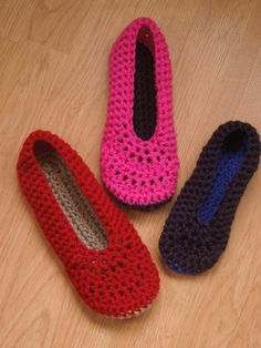 three crocheted slippers sitting on top of a wooden floor next to each other