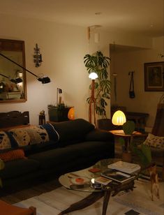 a living room filled with furniture and a lamp on top of a table next to a couch