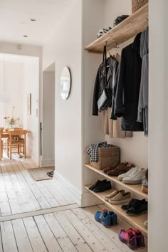 shoes are lined up on shelves in the entry way to a house with white walls