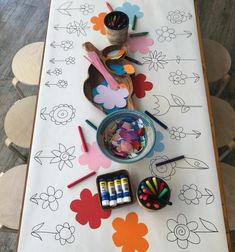 the table is covered with markers, crayons, and other art supplies on it