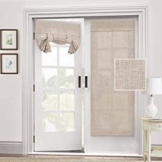 a living room with white walls and curtains on the sliding glass doors that lead to an outside patio