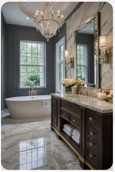 a large bathroom with marble floors and chandelier above the bathtub is shown