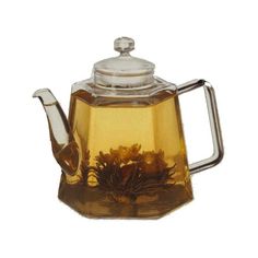 a glass tea pot filled with yellow flowers