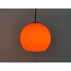 an orange ball light hanging from a ceiling