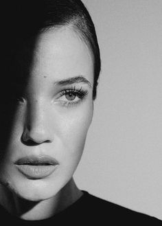 a black and white photo of a woman's face with her eyes wide open