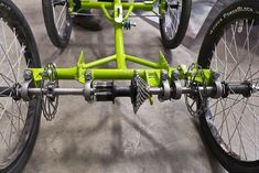 two green bicycles parked next to each other in a parking lot with wheels and spokes