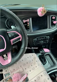 the interior of a car is decorated with pink and black accessories, including a steering wheel