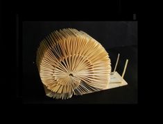 an open book that has been folded into a snail like structure with two forks sticking out of it