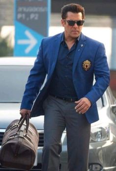 a man in a blue jacket carrying a brown bag