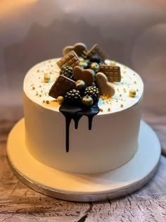 a white cake with chocolate and gold decorations