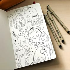 an open notebook with drawings on it next to two pencils