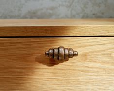 a close up of a wooden drawer with metal knobs on the top and bottom