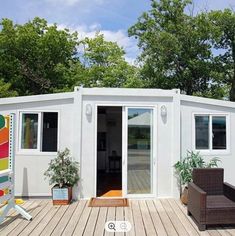 a small white house sitting on top of a wooden deck